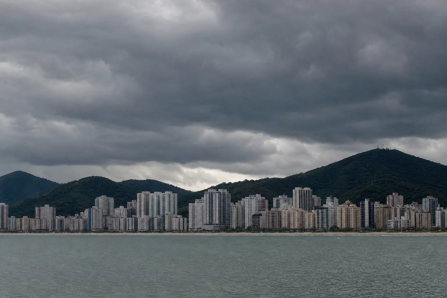 Nuvens carregadas de chuva sobre a orla de uma cidade litorânea